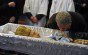 An orthodox believer bends to kiss a cro